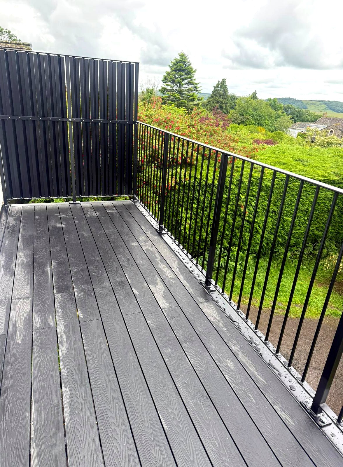 Custom louvred steel privacy screen on a black walkout balcony, Cumbria
